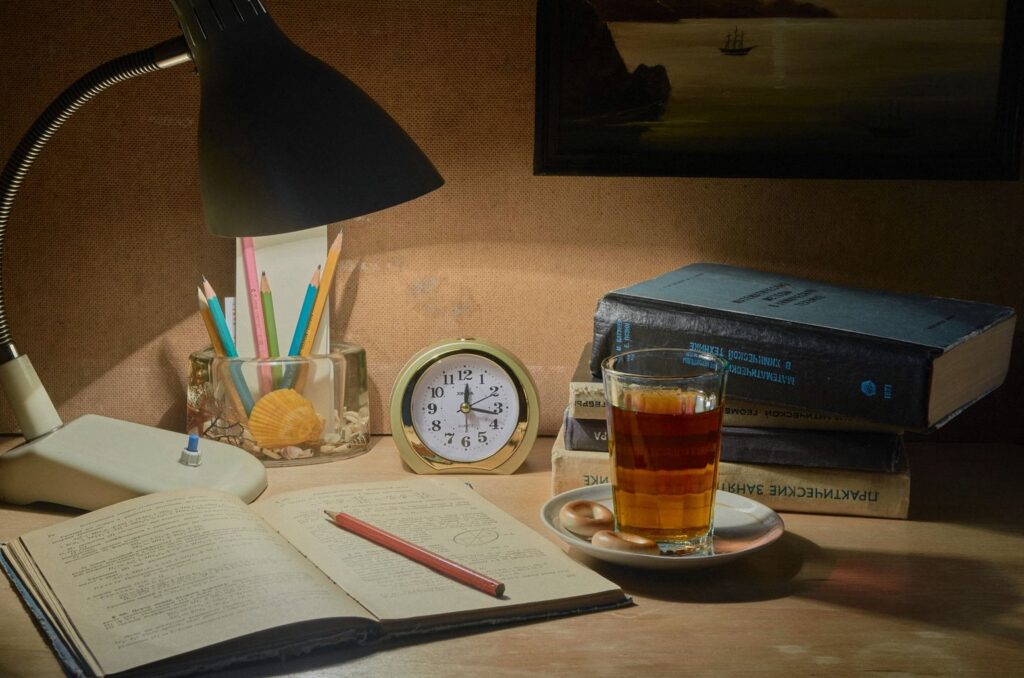 Otwarty zeszyt z ołówkiem na biurku przy lampce wieczorem